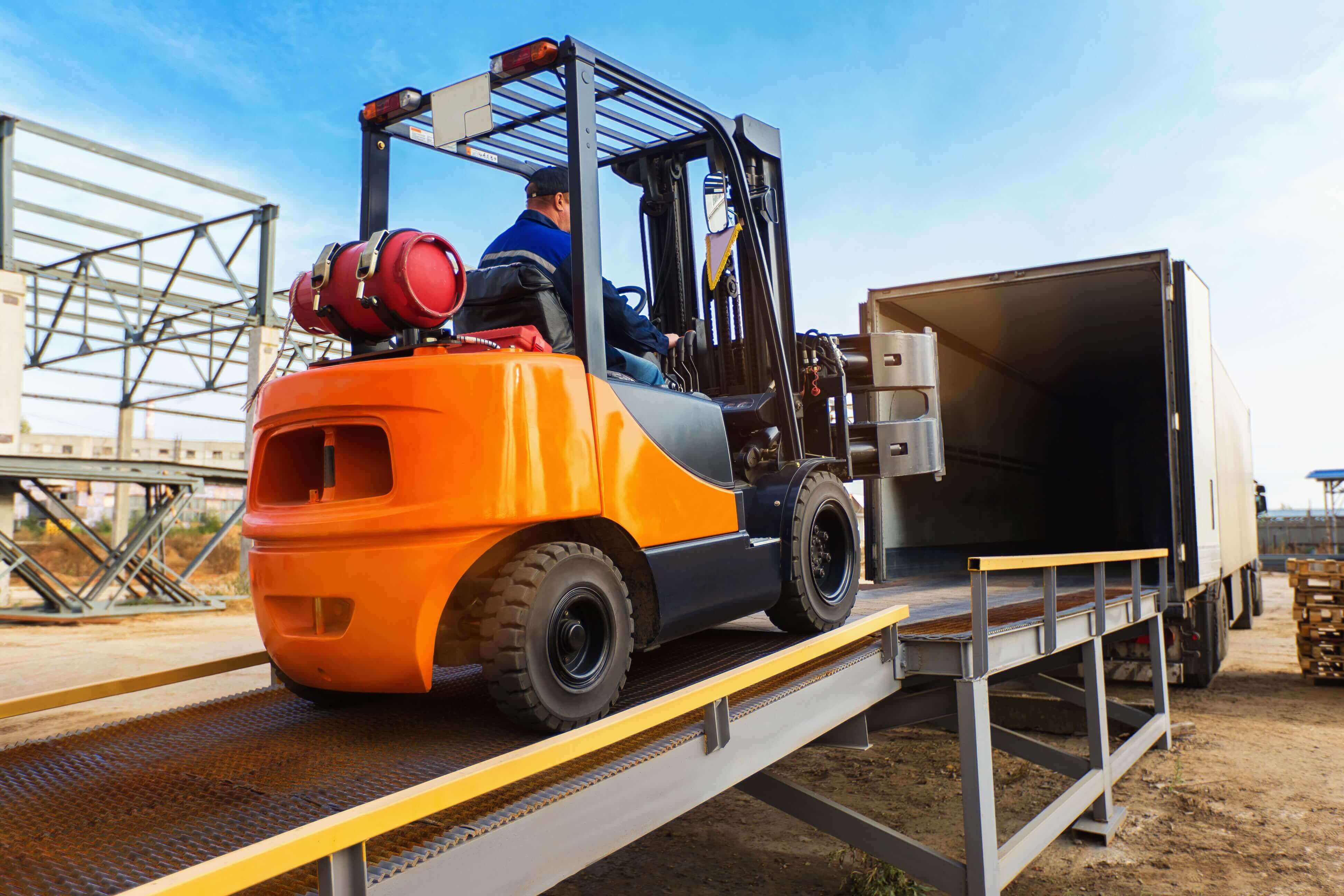 Forklift operator loading cargo into trailer at a warehouse