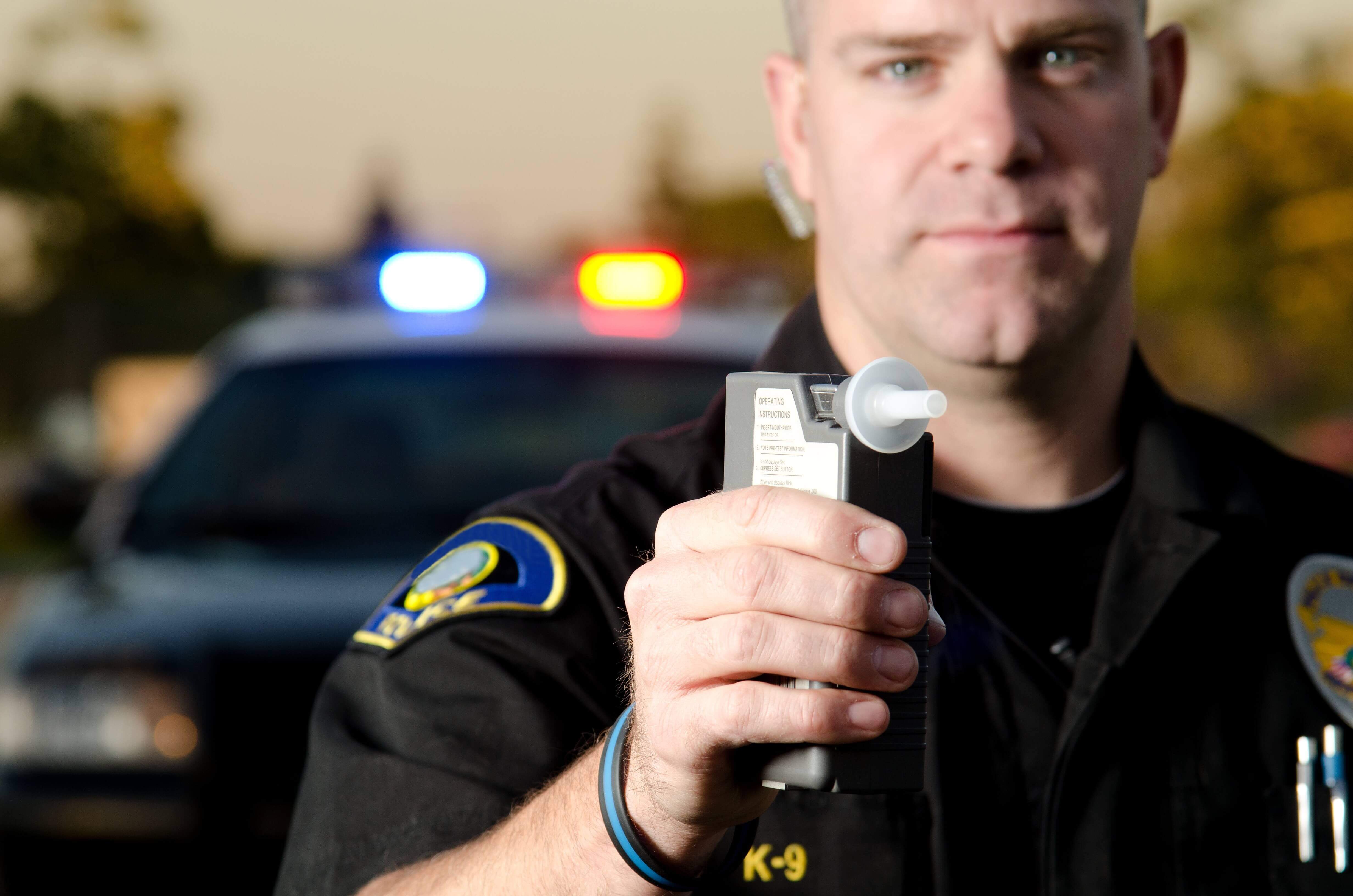 Target 25 DUI: Police officer holding breathalyzer outside vehicle